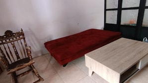 A room with a wooden chair, a red bench, and a light-colored table. - Hotel O Pondok Tawing Rumbih (Tamban)