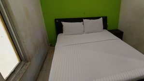 A small, narrow room with a single bed, a green wall, and a white door. - Hotel O Pondok Tawing Rumbih (Tamban)