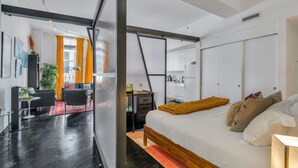 Een moderne slaapkamer met een groot bed, een bureau en een stoel.