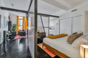 Un dormitorio moderno con una cama grande, un escritorio y una silla.