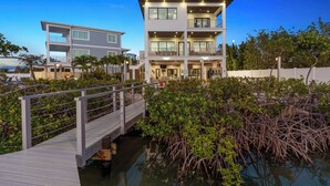 A multi-story beachfront property with a dock and mangrove vegetation. - Luxury Seaside Escape ~ Pool ~ Dock ~ Scenic Views (Marathon)