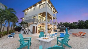A multi-story house with a pool, outdoor seating, and a fire pit. - Luxury Seaside Escape ~ Pool ~ Dock ~ Scenic Views (Marathon)