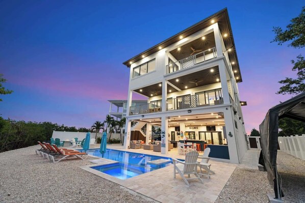 A multi-story building with a pool, outdoor seating, and a visible entrance labeled 'HOME'.