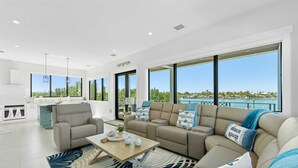 Ein modernes Wohnzimmer mit einer Couch, einem Couchtisch und Blick auf den Ozean.