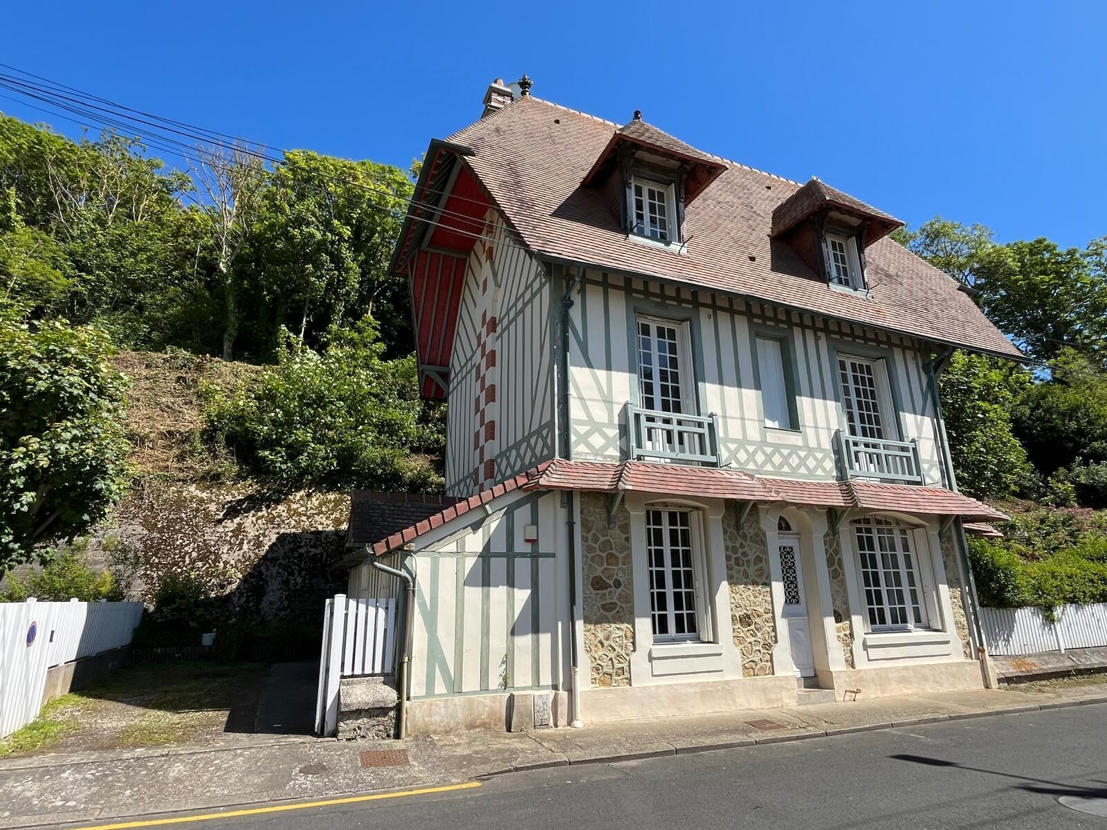 A two-story building with a stone facade and a red roof.