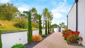 A modern building with a gravel pathway leading to a gated entrance. - Lovely home in Saint-Nazaire (Saint-Nazaire)