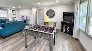 Una sala de estar con mesa de fútbol de mesa, un sofá, un televisor y un mueble para el fútbol de mesa.