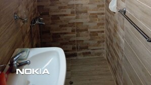Un baño con ducha, lavamanos y ventana.
