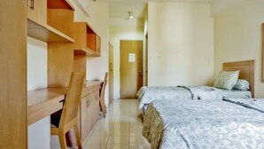 Un dormitorio con dos camas, un escritorio y una silla.