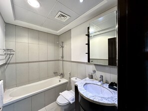 Ein modernes Badezimmer mit Badewanne, Toilette und Waschtisch.