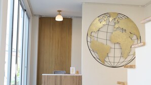 Un área de recepción con un escritorio de madera, un globo terráqueo decorativo en la pared y una escalera con escalones de madera.