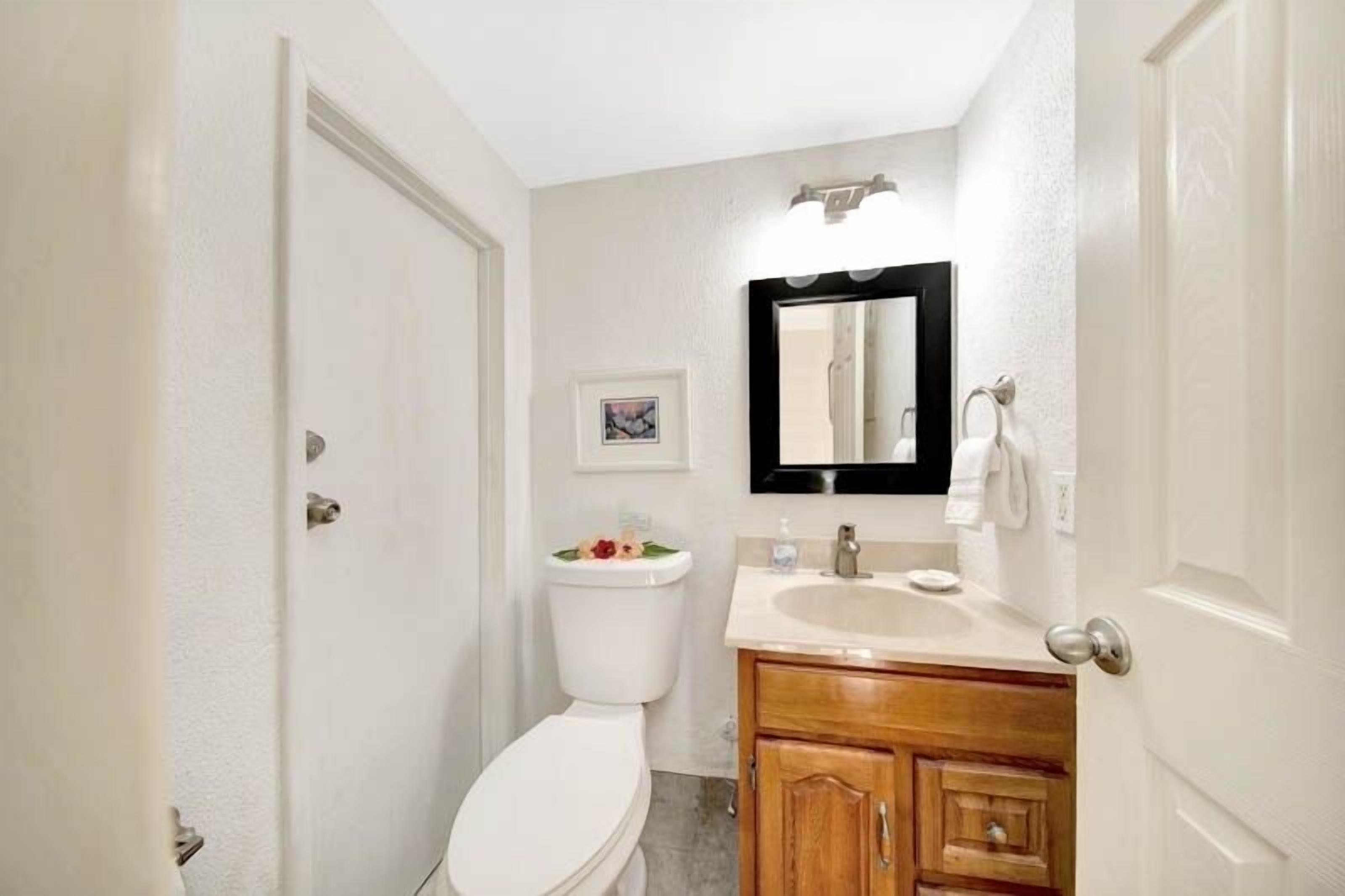 Un baño pequeño con inodoro, lavabo y espejo.