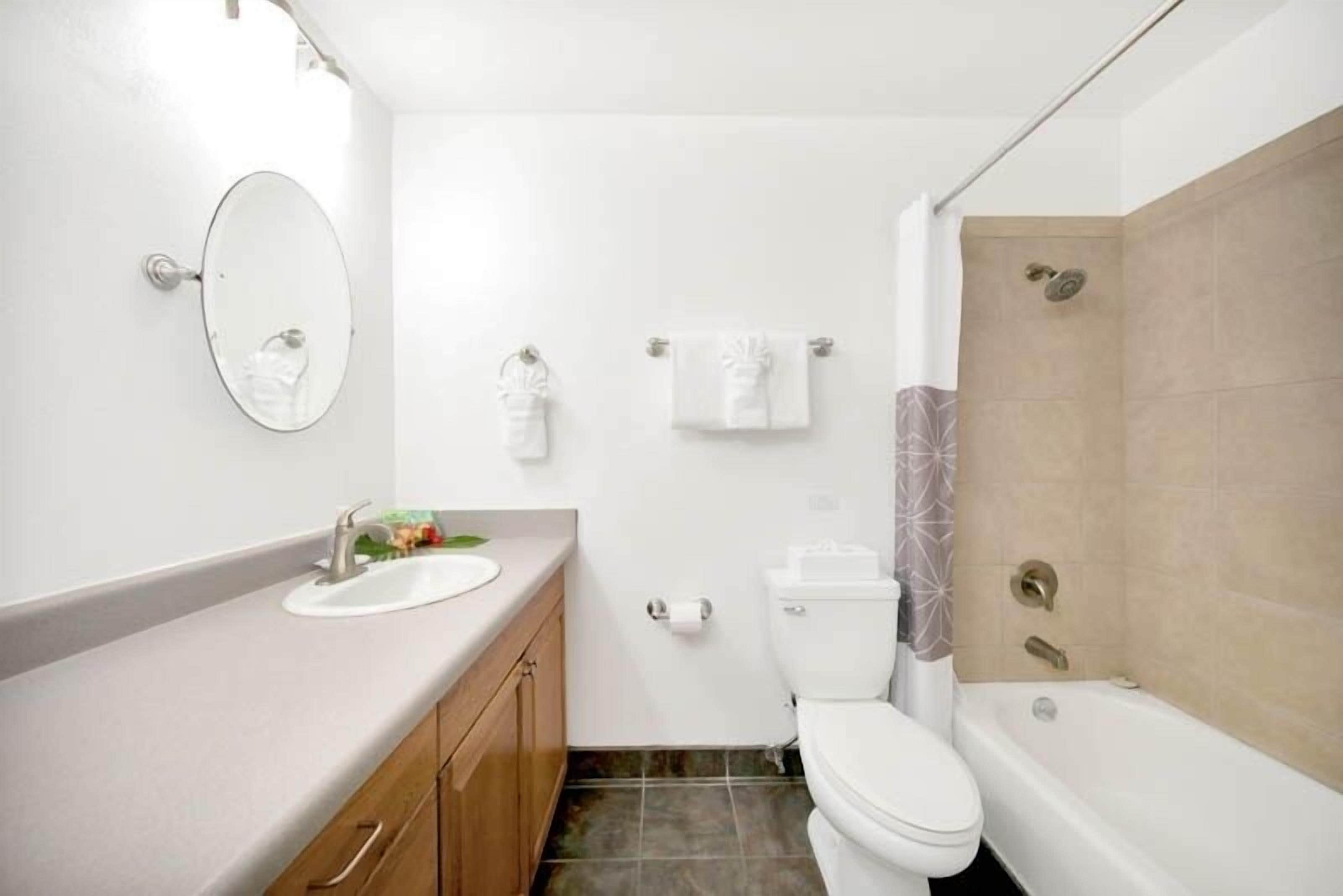 A modern bathroom with a sink, toilet, and bathtub.
