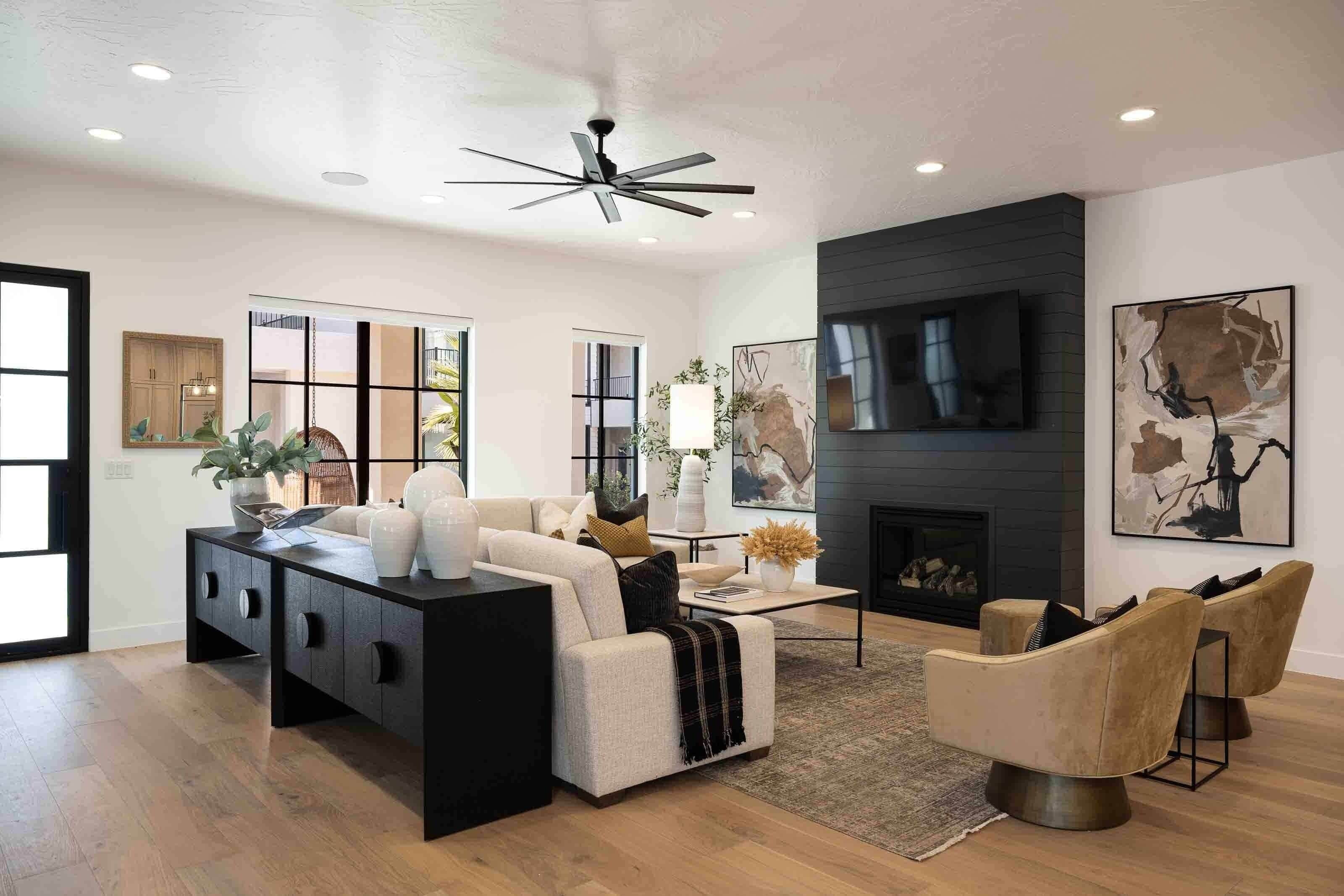 A modern living room with a sofa, armchairs, a coffee table, and a fireplace.