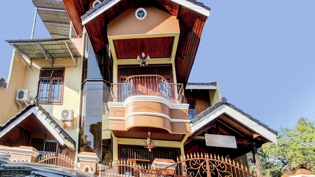 A multi-story building with a distinctive sloped roof, a balcony with ornate railings, and a sign indicating it is a guesthouse. - Hotel O Griya Pius Syariah Malioboro (Yogyakarta)