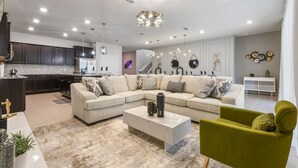 Una sala de estar moderna con un sofá modular, una mesa de centro y un sillón verde.