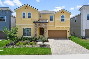A two-story house with a stone facade, a garage, and a well-maintained lawn.