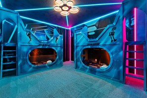 A Star Wars-themed room with circular bunk beds and neon lighting.
