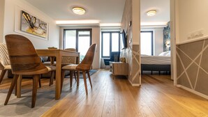 Une chambre d’hôtel moderne avec un coin repas, un lit et une grande fenêtre.