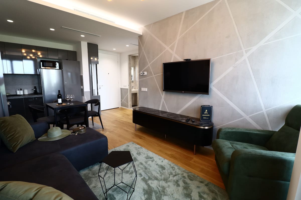 A modern living room with a sofa, a coffee table, and a TV mounted on the wall.