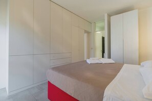 Une chambre d’hôtel avec un lit, une armoire et un miroir.
