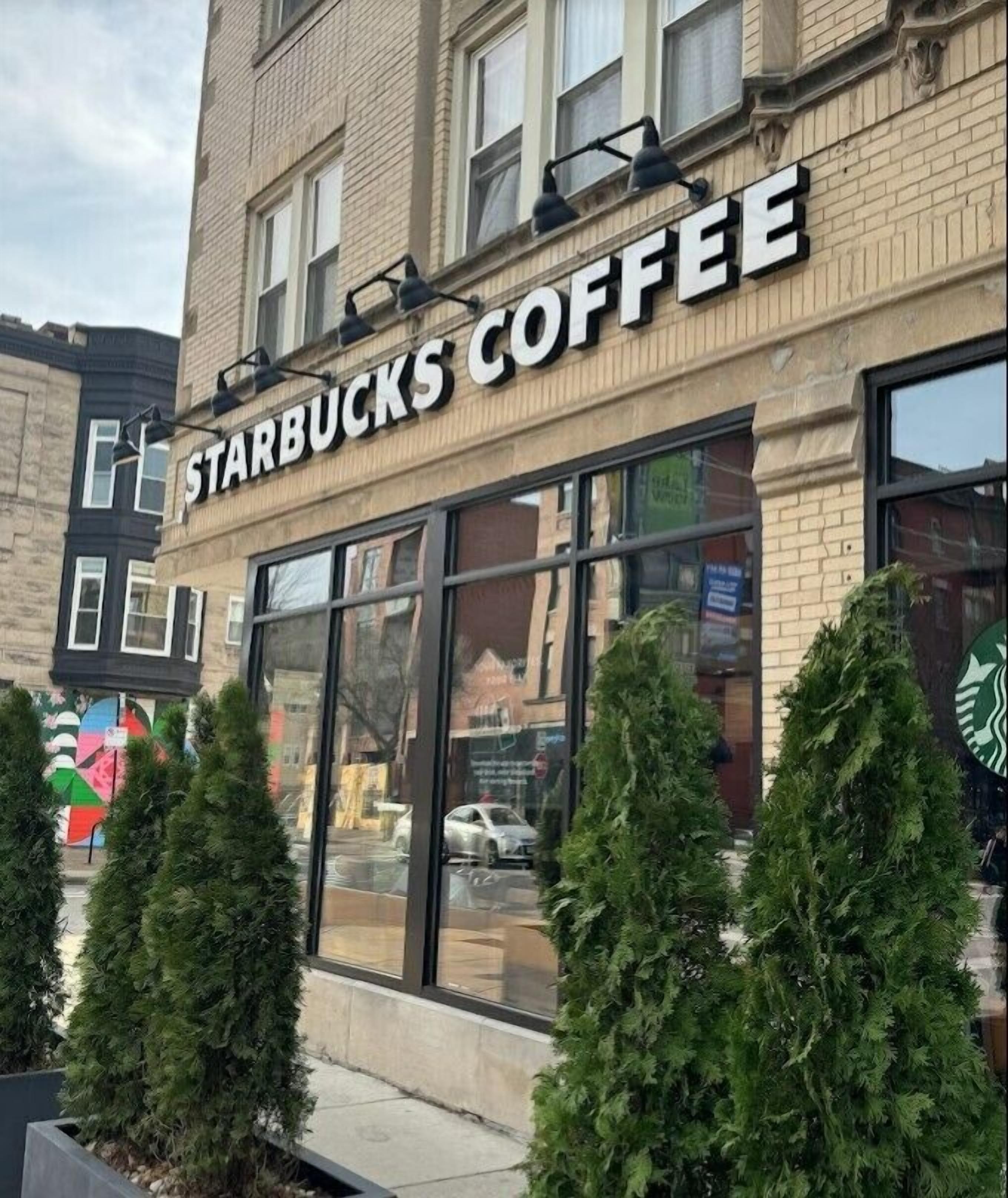 A Starbucks Coffee store with large windows and a brick facade.