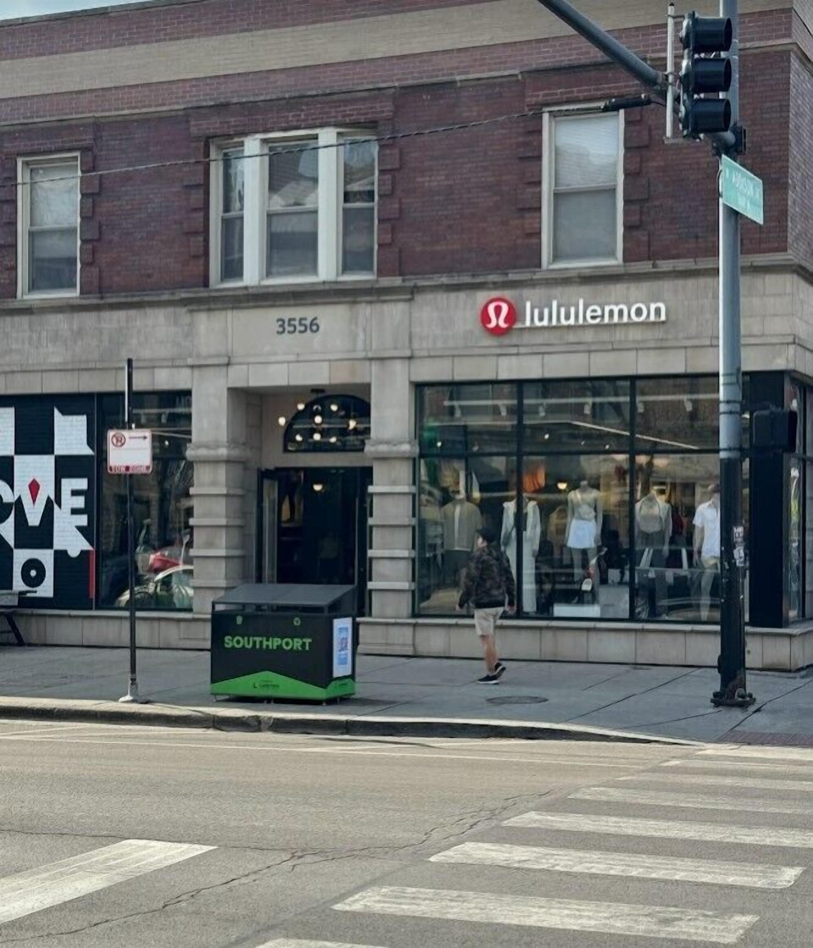 A building with a storefront labeled 'lululemon' and a 'Southport' sign on a trash bin.