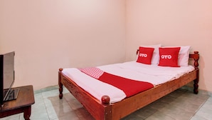 A single bed with a wooden frame and a red and white bedspread. There are two pillows with the word 'OYO' on them. A television is placed on a wooden table to the left of the bed. - Hotel O Pondok Wisata Sekar KemuningNearWonogondang Camp ( Bumi Perkemahan Wonogondang ) (Cangkringan)