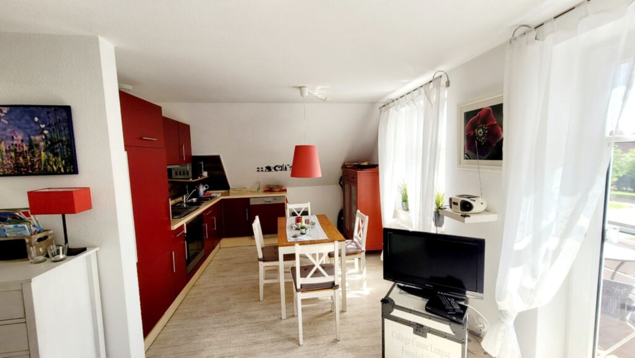 A compact living space with a kitchenette, dining area, and a television.