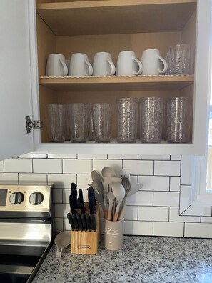 A kitchen with a stainless steel stove, a knife block, and a utensil holder on the counter. - Farmhouse styled, pet friendly home close to everything!  (Wilmington)