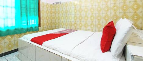 Une pièce avec un lit, une fenêtre avec un rideau et des carreaux muraux à motifs.
