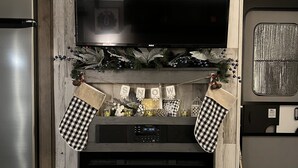 A modern living room with a fireplace, a television, and a pet bed. - Cozy camper in Clemson Hills.  5 minutes from Clemson University.  Pet friendly! (Seneca)
