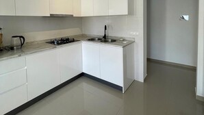 A modern kitchen with white cabinets, a gas stove, and a sink. - Biss Apartments Mindelo - T1 Madalena nearby the beach (Mindelo)