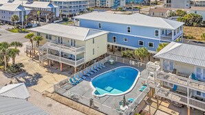 Ett hotell vid stranden med en swimmingpool, flera balkonger och utsikt över havet.