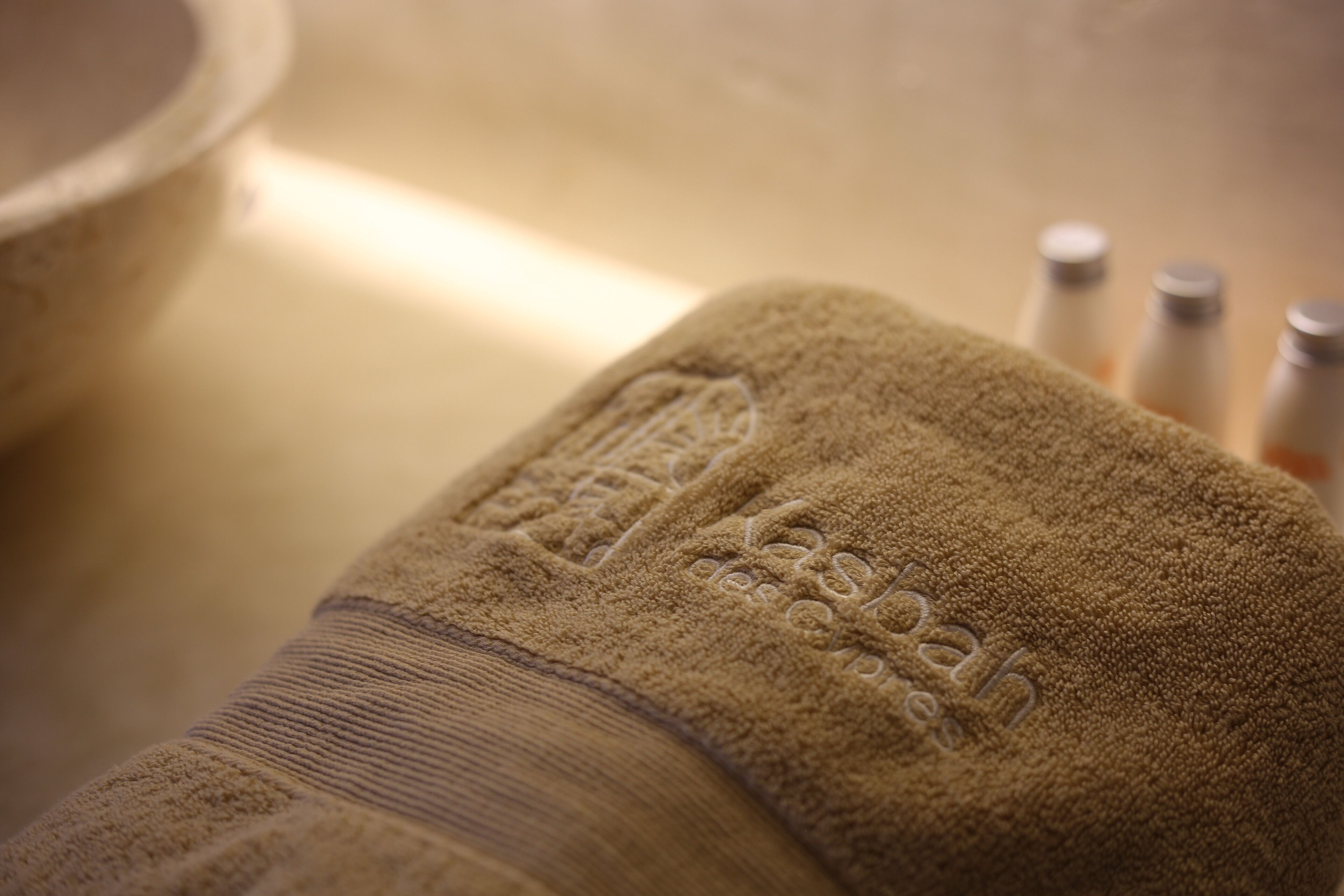 A close-up of a textured brown towel with embossed text.