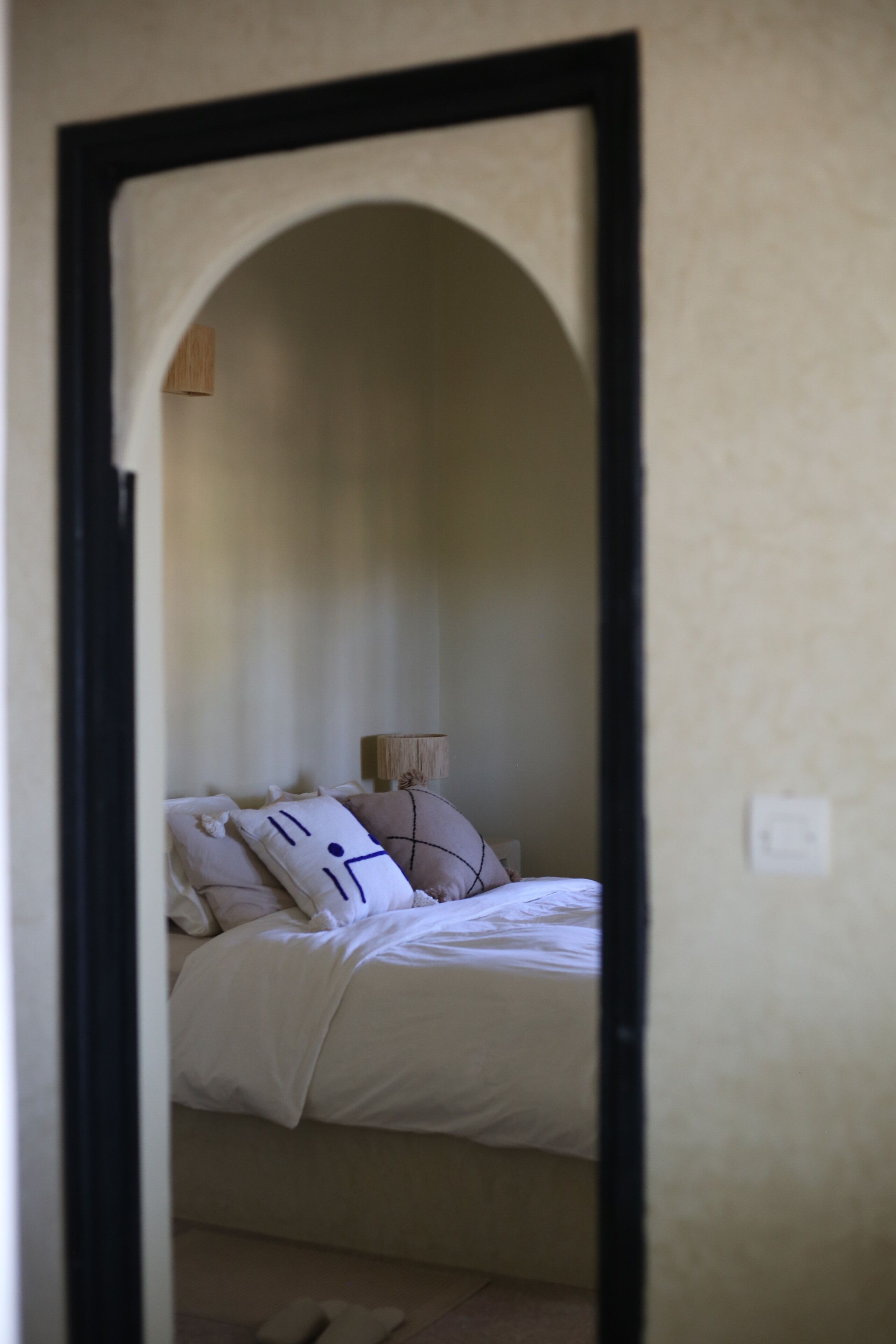 Une chambre à coucher avec un lit, des oreillers et une table de chevet.