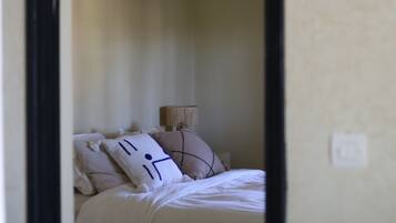 Une chambre à coucher avec un lit, des oreillers et une table de chevet.