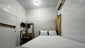 A bedroom with a bed, a wooden chair, a mirror, and a television on the wall. - Hotel O Pondok Bulo Ugi Syariah Near SD Negeri 185 Pinrang (Binanga Karaeng)