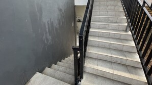 A staircase with a black metal railing, leading to a higher floor. - Hotel O Pondok Bulo Ugi Syariah Near SD Negeri 185 Pinrang (Binanga Karaeng)
