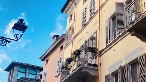 Un edificio de varios pisos con balcones y persianas.