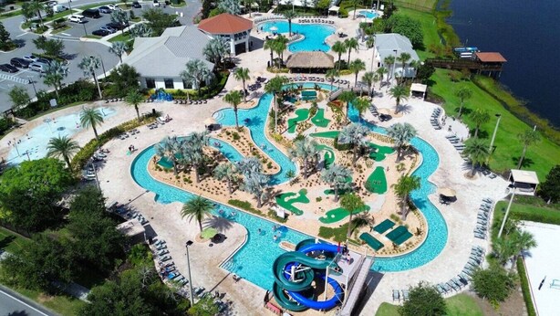 An aerial view of a resort with multiple swimming pools, a water slide, and a golf course. - Family 4BR w/ Private Pool near Disney Parks! (Kissimmee)