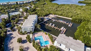 Vista aerea di un resort con una marina, piscina e proprietà sulla spiaggia.