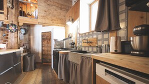 A kitchen with wooden cabinets, a stove, and a sink. - Le Chalet du Papote (Aussois)