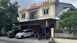 A two-story building with a covered parking area and a gated entrance. - OYO 93412 Kost Irma Syariah Near UPTD SMP Negeri 8 Parepare (Parepare)