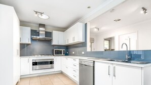 A modern kitchen with white cabinets, stainless steel appliances, and a dishwasher. - 4BR/2BA House Nestled in a Quiet Spot in Dickson (Dickson)