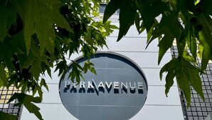 Een bord met PARK AVENUE, omringd door groen groen.