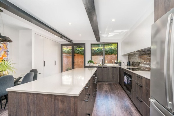A spacious kitchen with rustic brick splashback and warm timber tones. Perfect for gathering and enjoying meals.