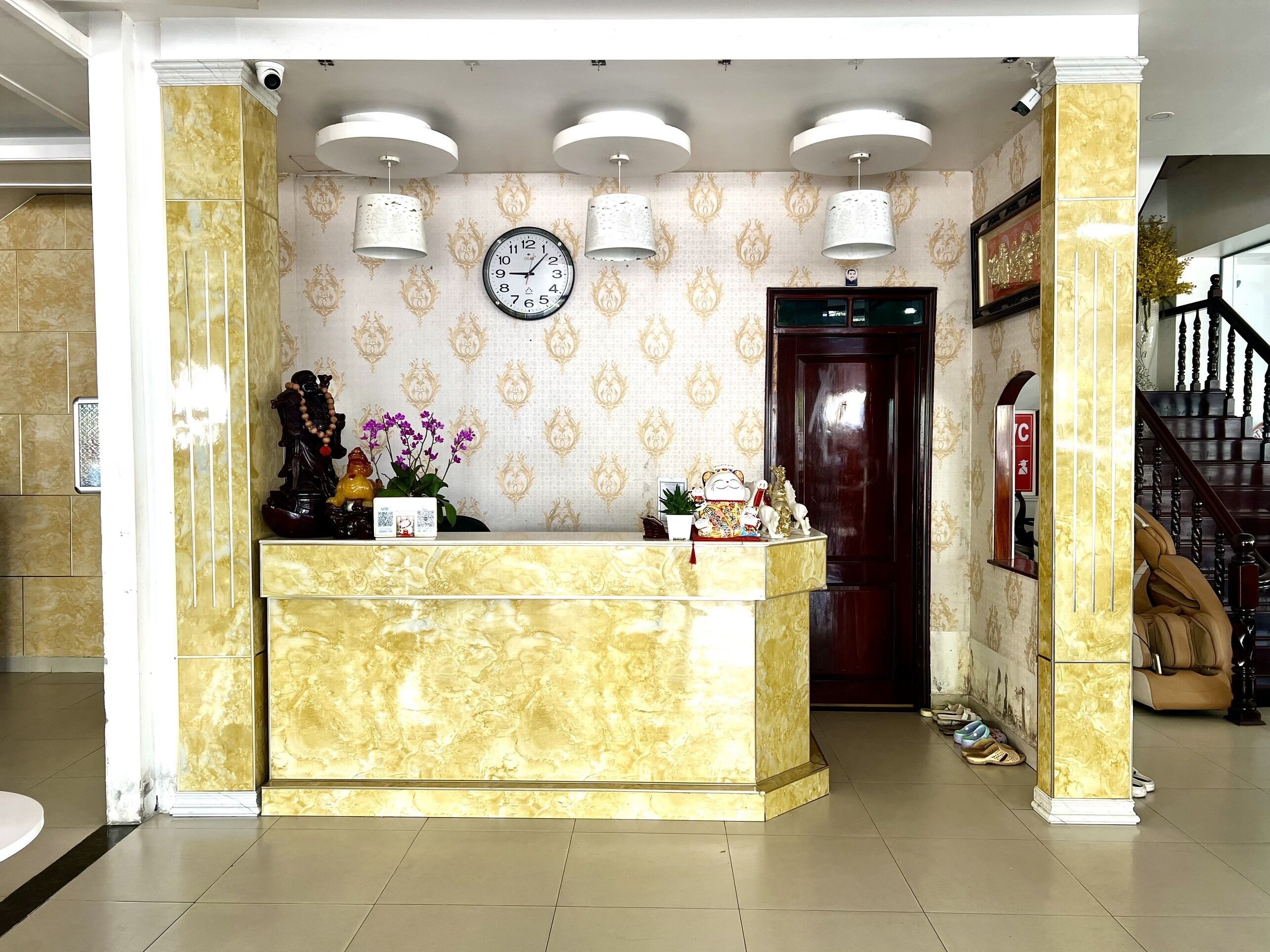 A reception area with a marble counter, a clock, and decorative items.