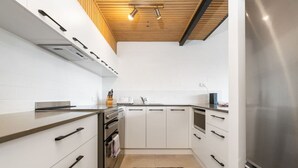 A modern kitchen with white cabinetry, stainless steel appliances, and a wooden ceiling. - 3BR Loft Apt 1min to Kingston Foreshore! (Kingston)
