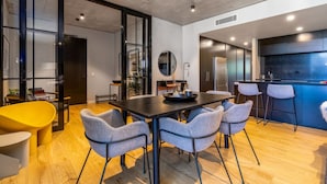 A modern kitchen with a dark countertop, a round mirror, and a built-in oven. - Onyx Apt · Onsite EV Charger · 5mins to Foreshore (Kingston)